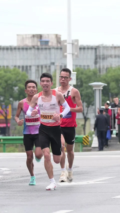 Group of Five Marathon Runners Approaching Camera on Urban Avenue Stock-Footage 348071081