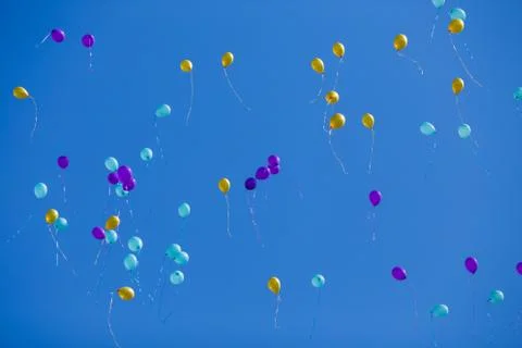 Group of floating multicolored balloons in the blue sky Foto stock