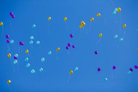Group of floating multicolored balloons in the blue sky Foto stock
