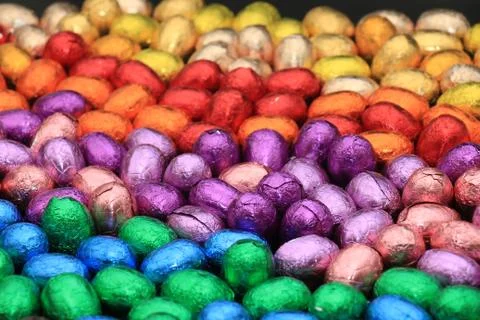 A group of foil wrapped chocolate easter eggs in rainbow colors Stock Photos
