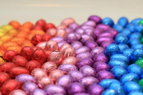 A group of foil wrapped chocolate easter eggs in rainbow colors Stock Photos
