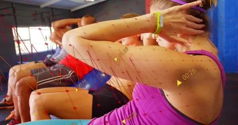 Group following instructor cue, crunching on exercise balls to engage core with Stock Footage 318689335
