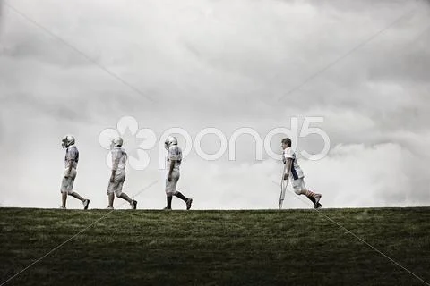 A Group Of Football Players, Young People In Protective Helmets.