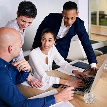 Group of four executives working together to brainstorm promotional ideas Stock Photos