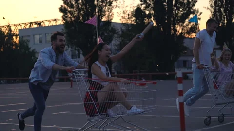 Group of four friends running with carts at the parking. Stock Footage 110302106