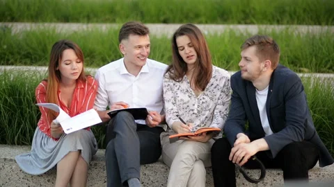 Group Of Four Students Sitting In Park And Talking To Each Other. They Are Video stock 111765548