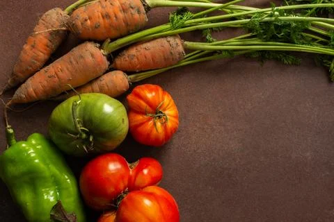 A group of fresh vegetables is placed in a circle on a wooden table. There ar Stock Photos