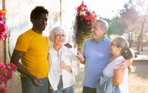 A group of friendly multiracial mixed-sex mature adult people standing outside Stock Photos