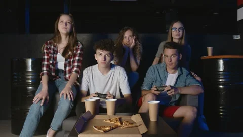 Group of friends are having fun with video game at home, one boy is winning Video stock 136335680