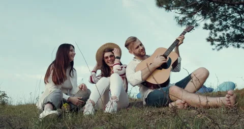 A group of friends are having fun and smiling sitting down in the park. Stock Footage 139284798