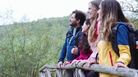 Group of friends are taking a break during a hike while they are looking at view Stock Footage 240983682