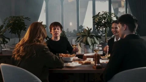 Group of friends chatting at a table in restaurant Stock Footage 314893319