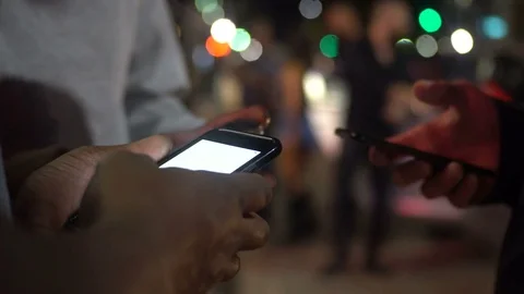 Group of friends checking social media using app on smart phone at night in city Stock Footage 75325073