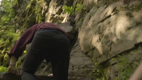 Group Of Friends Climb Up Rocky Cliff Together, Her Friend Helps Her Up Stock Footage