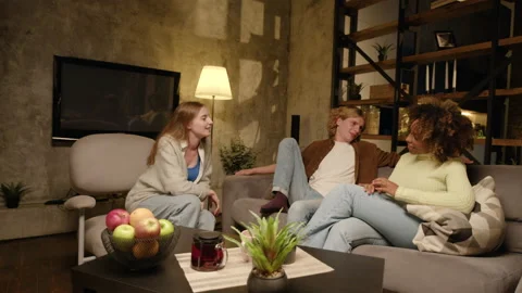 A group of friends comes into the frame, sit down, talk, smile in the evening 스톡 동영상 220559904