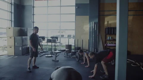 Group of friends completing burpees and celebrating in the gym together Stock Footage 312702041