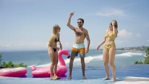 Group friends dance on infinity pool party in beach club with ocean view Stock Footage 269120447