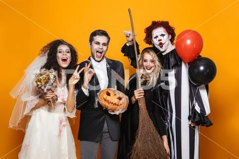 Group of friends dressed in scary costumes celebrating Stock Photos