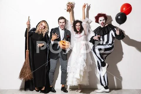 Group of friends dressed in scary costumes celebrating Stock Photos