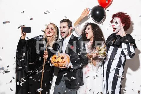 Group of friends dressed in scary costumes celebrating Stock Photos