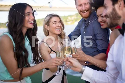 Group of friends drinking, chatting and having a fun at outdoor party Stock Photos