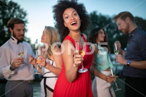 Group of friends drinking, chatting and having a fun at outdoor party Stock Photos