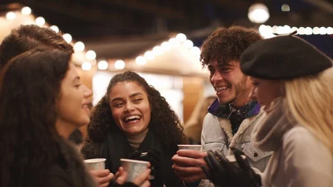 Group Of Friends Drinking Mulled Wine At Christmas Market Stock Footage