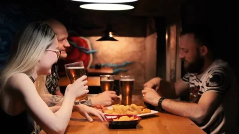 Group of friends drinking in pub, young people talking and having fun with beer Video stock 199217862