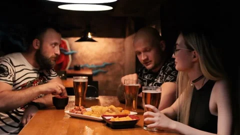 Group of friends drinking in pub, young people talking and having fun with beer 스톡 동영상 199218256