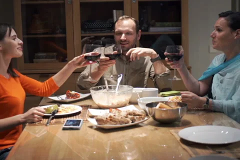 Group of friends drinking red wine by table at home NTSC Stock Footage 57539682