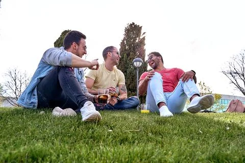 Group of friends drinking refreshing drinks while relaxing together outdoors in Foto stock