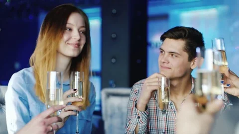 Group of friends drinking wine in a restaurant or cafe, clink glasses. Stock Footage 72683491