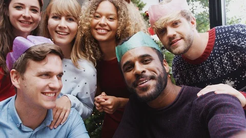 Group Of Friends Enjoying Christmas Party At Home Together Taking Selfie Stock Footage