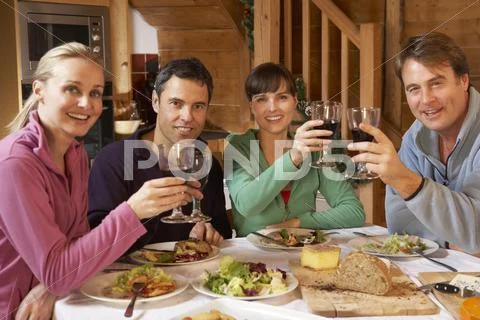 Group Of Friends Enjoying Meal In Alpine Chalet Together Stock Photos