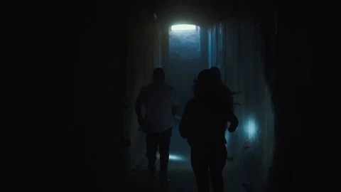 Group of friends with flashlights running through dark tunnels Stock Footage 195764589