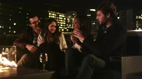 A group of friends have drinks on a rooftop bar at night and take pictures Video stock 44189099