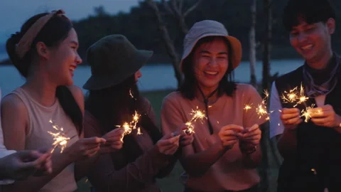 Group of friends having fun camping party outdoor with sparkles light Stock Footage 243974473