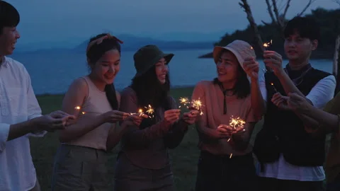 Group of friends having fun camping party outdoor with sparkles light Stock Footage 243974510