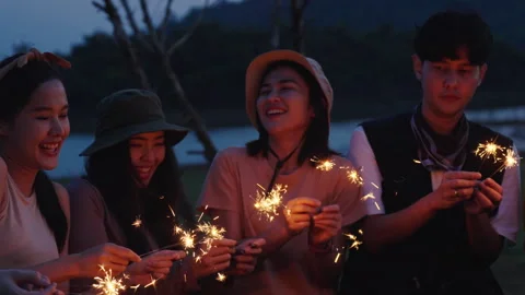 Group of friends having fun camping party outdoor with sparkles light Stock Footage 243974590