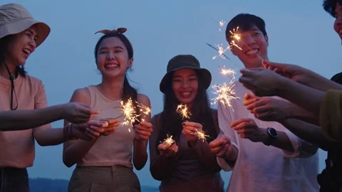 Group of friends having fun camping party outdoor with sparkles light Stock Footage 243974634