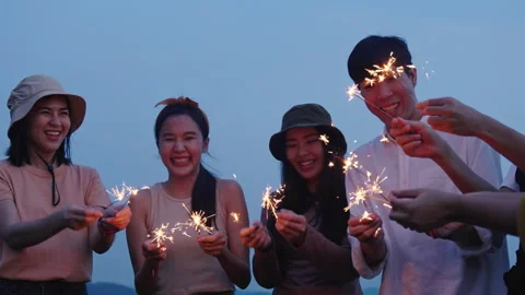 Group of friends having fun camping party outdoor with sparkles light Stock Footage 243974637