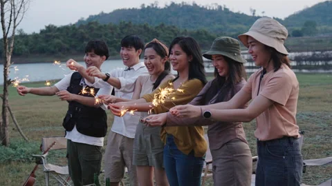 Group of friends having fun camping party outdoor with sparkles light Stock Footage 243974683