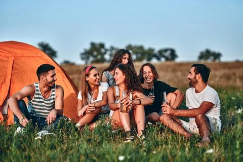 Group of friends having fun outside tents on camping holiday Stock Photos