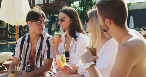 Group of friends having fun at pool. People cheers drinking summer cocktails at Video stock 158214970
