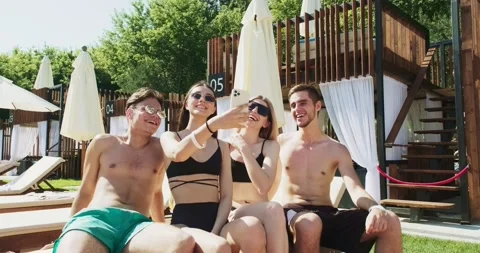 Group of friends having fun at pool. Taking selfie on smartphone sitting Stock Footage 158216802