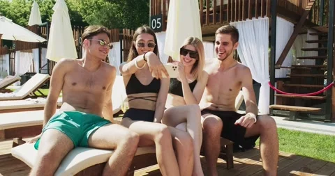Group of friends having fun at pool. Taking selfie on smartphone sitting Stock Footage 158373305