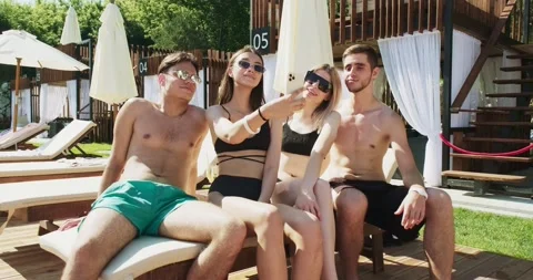 Group of friends having fun at pool. Taking selfie on smartphone sitting Stock Footage 158481103