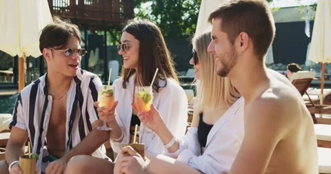Group of friends having fun at pool. People cheers drinking summer cocktails at Video stock 158608464
