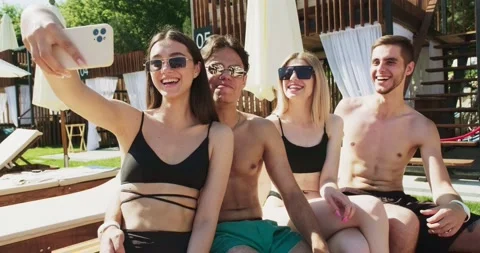 Group of friends having fun at pool. Taking selfie on smartphone sitting Stock Footage 158609859