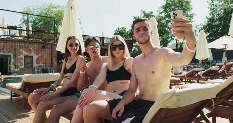 Group of friends having fun at pool. Taking selfie on smartphone sitting Stock Footage 158610241